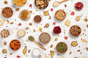 Healthy vegetarian food concept. Assortment of dried fruits, nuts and seeds on white background. Top view. photo