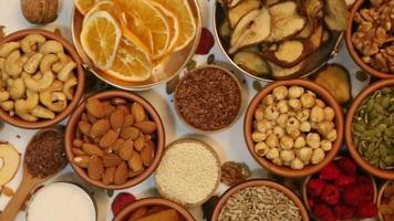 Healthy vegetarian food concept. Assortment of dried fruits, nuts and seeds on white background. Top view. video