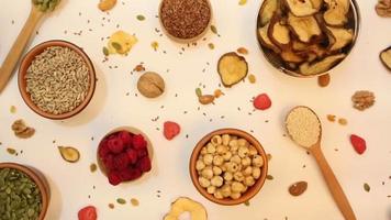 Healthy vegetarian food concept. Assortment of dried fruits, nuts and seeds on white background. Top view. video