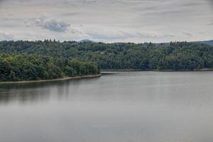 paisaje de el laguna a el represa en dobczyce en Polonia en un calentar verano nublado día foto