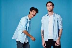 friends in unbuttoned shirts and white t-shirts jeans blue background fun communication party photo