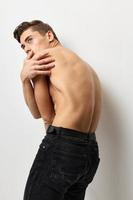 Fashionable man stands with back nude torso posing studio cropped view photo