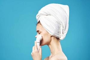 emocional mujer con toalla en cabeza facial masajeador piel cuidado foto