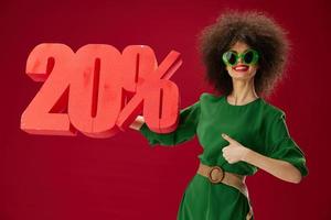 pretty woman holding red twenty percent discount advertising red background unaltered photo