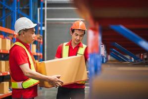 Working at factory warehouse. Warehouse worker holding cardboard box, Warehouse workers team moving boxes on the shelf photo