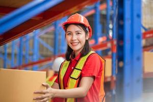 Female warehouse worker working in factory warehouse industry, Cheerful young woman working in logistics center photo