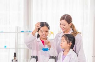 Elementary science class, Cheerful kid girl with teacher scientist in school laboratory, Science laboratory photo