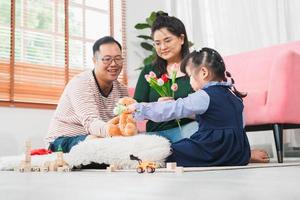 Asian family playing in the living room, Kid girl daughter mother and father play toy in the house photo
