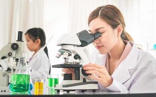 Elementary science class, Female teacher scientist with kid girl in school laboratory, Science laboratory photo