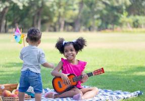 Sister and brother playing outdoor, Cute children are playing in park, Boy and girl play in yard photo