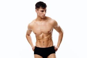handsome man with a pumped-up torso holding his hands on his belt on isolated background photo