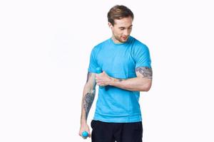 sporty man with a tattoo on his arm in a blue t-shirt and muscles bodybuilding fitness photo