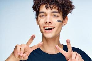 hermoso chico con Rizado pelo aplica un negro máscara en su cara cosmetología foto