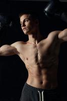 guy with a pumped-up torso gesturing with his hands on a black background boxing gloves fitness athlete photo