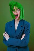 Beauty Fashion woman wearing a green wig blue jacket posing green background unaltered photo