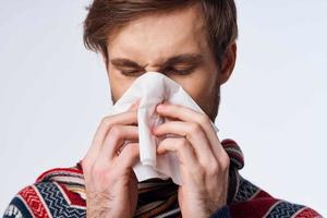 sick man with a handkerchief health problem flu symptoms light background photo