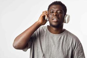 Cheerful man of African appearance in headphones listens to music photo