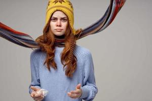 red-haired woman neck scarf with a hat on his head light background photo