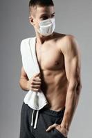 sport man with towel on shoulders medical mask health problem protection cropped view photo