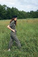 Woman in the field In green jumpsuit walk black cap fresh air photo