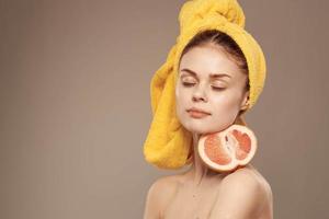 woman with grapefruit in hands naked shoulders and skin care vitamins photo