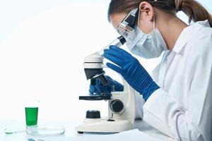 mujer científico mirando mediante un microscopio investigación biología diagnósticos foto