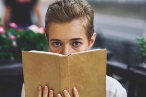 estudiante con un libro en su manos al aire libre descanso divertido caminando alrededor pueblo educación foto