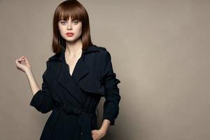Charming woman on an isolated background in a black coat photo