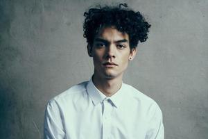 guy with curly hair in a white shirt curly hair emotions official photo