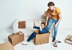 young couple sitting on white couch boxes moving lifestyle photo