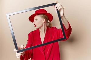 portrait of a woman with wooden frame posing red suit Lifestyle posing photo