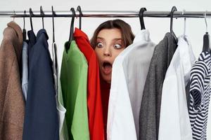 pretty woman in a red jacket near the wardrobe isolated background photo