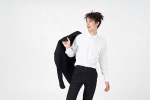 man with curly hair and in a classic suit holds a jacket in his hand fashion style photo