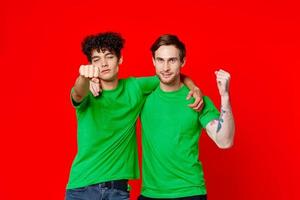 Two man green t-shirts embrace emotions friendship red background photo