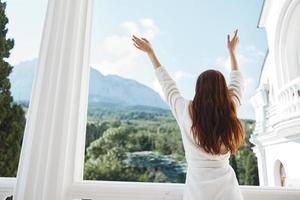 pretty woman looks at a beautiful view from the balcony back view photo