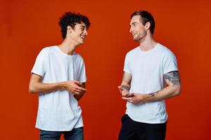 dos amigos en blanco camisetas abrazos comunicación rojo antecedentes foto