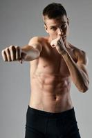Boxer en un gris antecedentes desnudo torso cubitos en el estómago carrocero foto