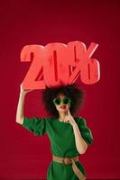 Beautiful fashionable girl holding red twenty percent discount advertising color background unaltered photo