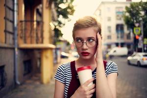 corto peludo mujer vistiendo lentes al aire libre caminar ocio bebida taza foto