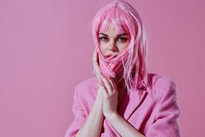 Beautiful fashionable girl pink jacket holding hair cosmetics pink background unaltered photo