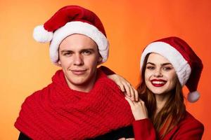 funny man and woman christmas santa hat friendship red background photo