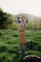 Portrait of a young girl on a summer day in the rays of the setting sun with a beautiful smile, dressed as a farmer and gardener photo