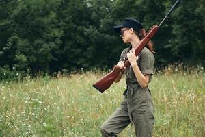 Woman soldier holding a gun hunting travel black cap photo