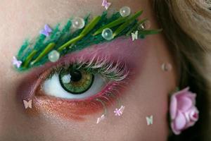 Eyes of a girl model with extended eyebrows and eyelashes. Part of the face with bright spring makeup. photo