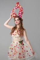 Fairy-tale girl model with floral horns. Maleficent. Spring or summer beauty. Woman in the image of a flower. Flower makeup. photo