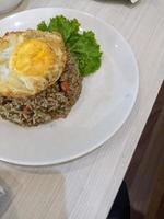 Fried rice the traditional food of Indonesia with lettuce and egg. The photo is suitable to use for traditional food background, poster and food content media.