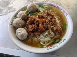 Close up photo of mie ayam traditional food of Javanese with meat ball. The photo is suitable to use for traditional food background, poster and food content media.