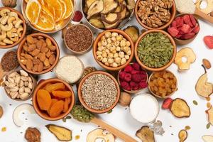 Healthy vegetarian food concept. Assortment of dried fruits, nuts and seeds on white background. Top view. photo