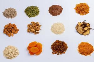 Healthy vegetarian food concept. Assortment of dried fruits, nuts and seeds on white background. Top view. photo