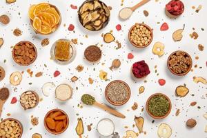 Healthy vegetarian food concept. Assortment of dried fruits, nuts and seeds on white background. Top view. photo